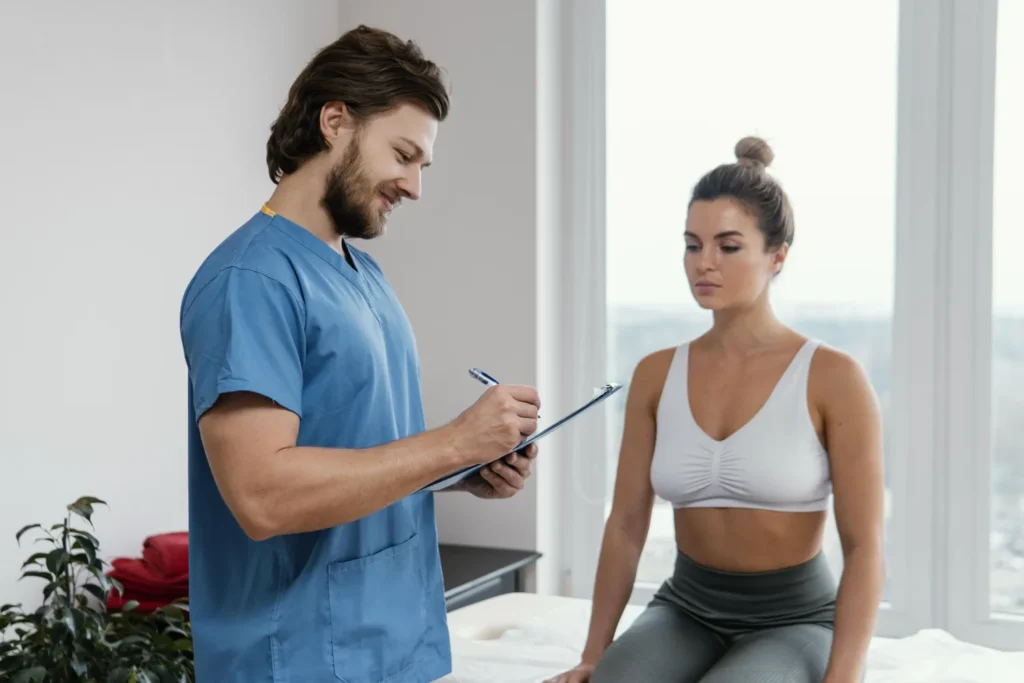 male-osteopathic-therapist-with-female-patient-signing-clipboard-office